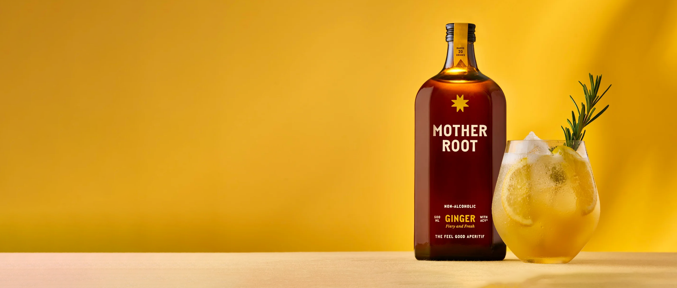 Bottle and glass of Mother Root ginger drink on a yellow background.