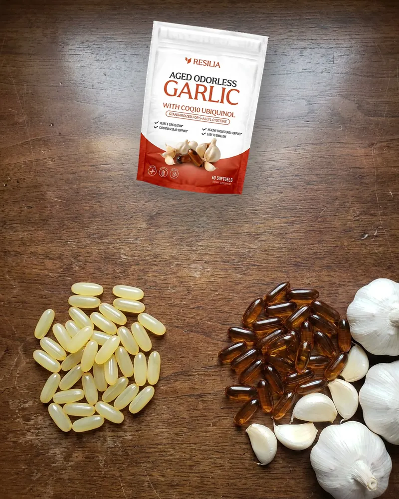 Pale yellow garlic oil softgels next to amber aged garlic softgels, with the Resilia pouch