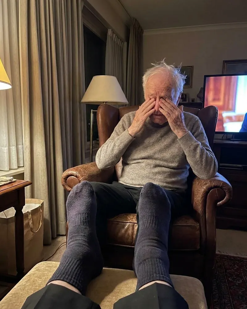 An older man resting in his armchair in the evening, feet up