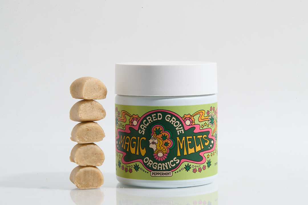 Jar labeled 'Sacred Grove Magic Melts' with stacked beige pieces beside it.