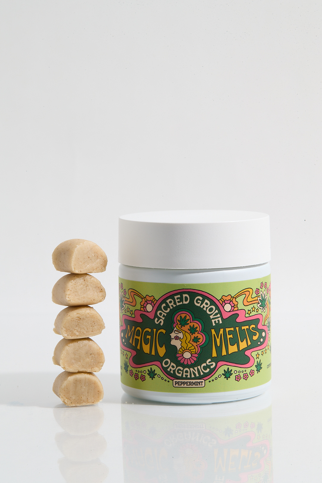 Jar labeled 'Sacred Grove Magic Melts' with stacked beige pieces beside it.