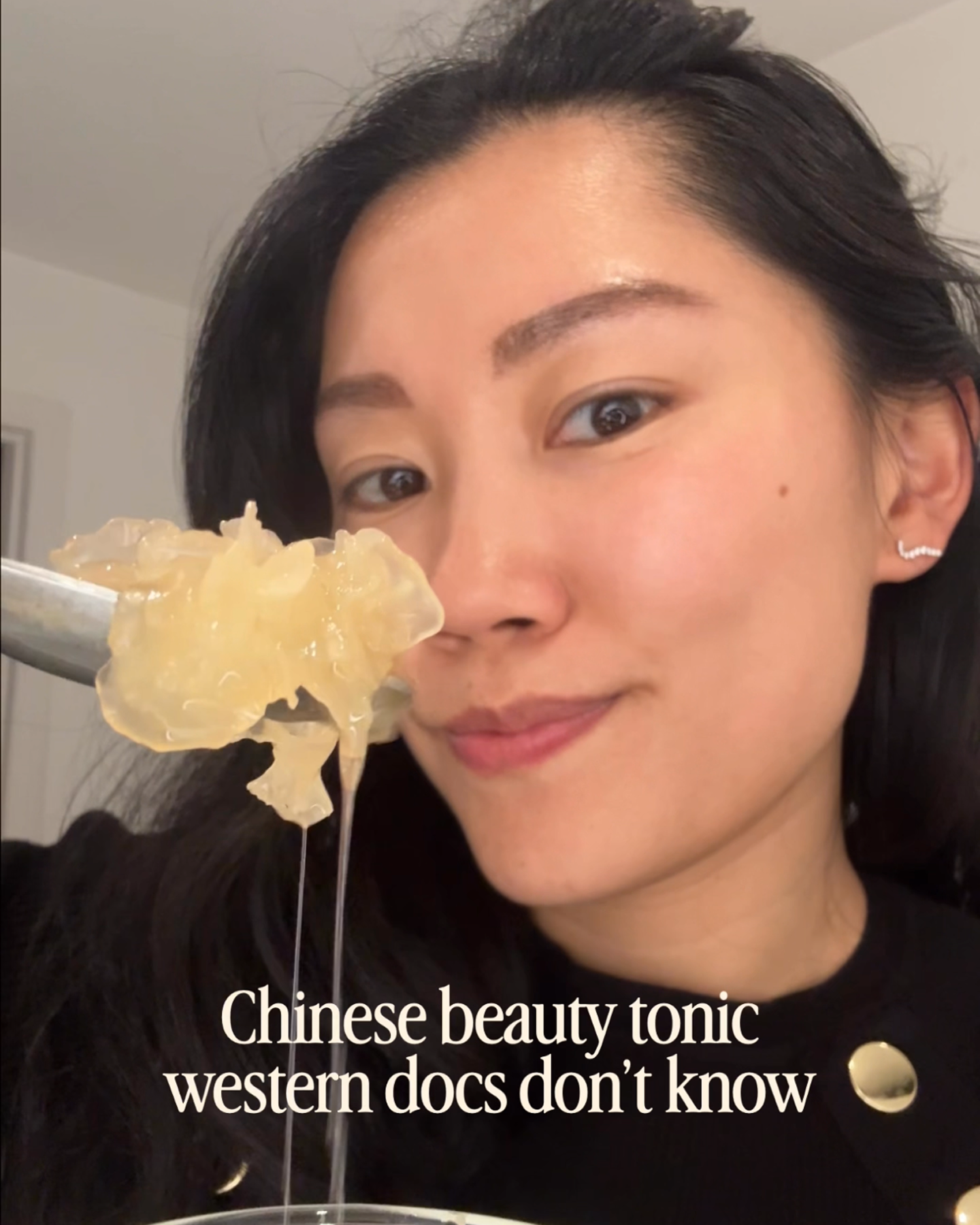 A woman holds up a spoon with a translucent, gelatinous substance to the camera.