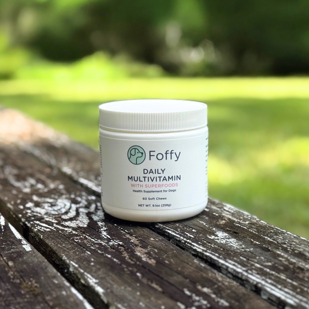 Container of dog multivitamins on a wooden table outdoors.