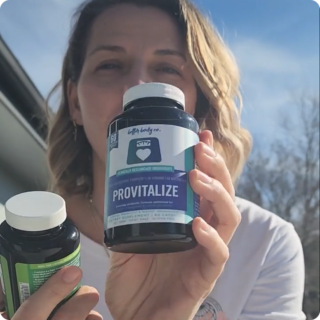 A woman holds up two bottles of Provitalize supplements outdoors, with one bottle featured prominently.