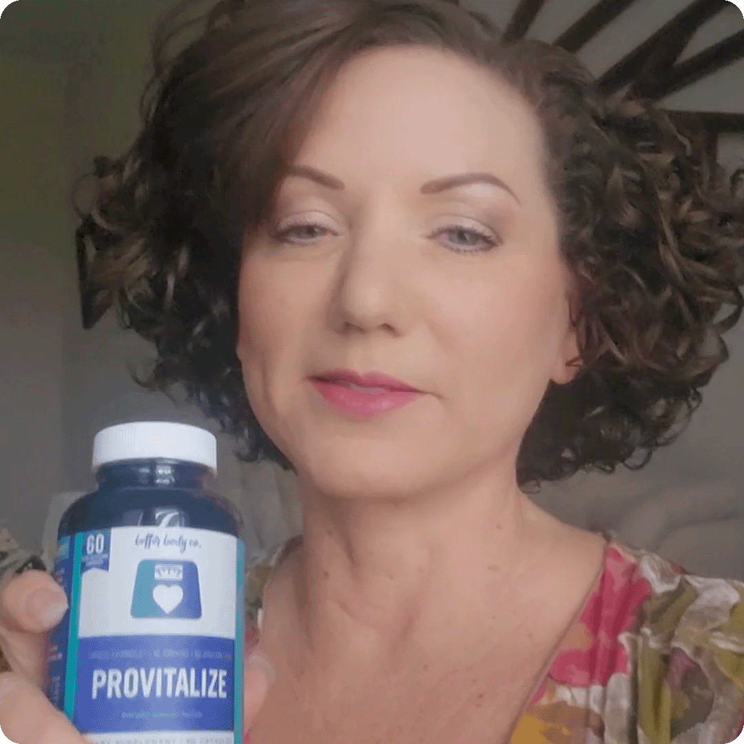 A woman with short, curly brown hair holds up a blue bottle of Provitalize supplements.