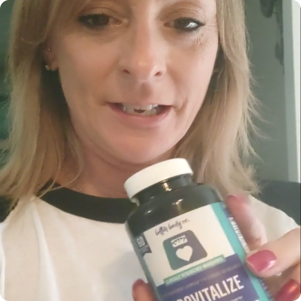 A blonde woman in a t-shirt holds up a bottle of Provitalize supplements while speaking.