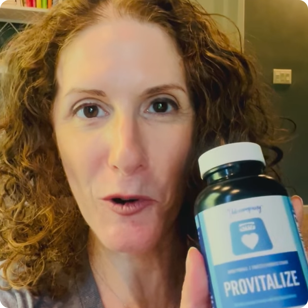 A woman with curly brown hair holds up a bottle of a supplement called Provitalize.