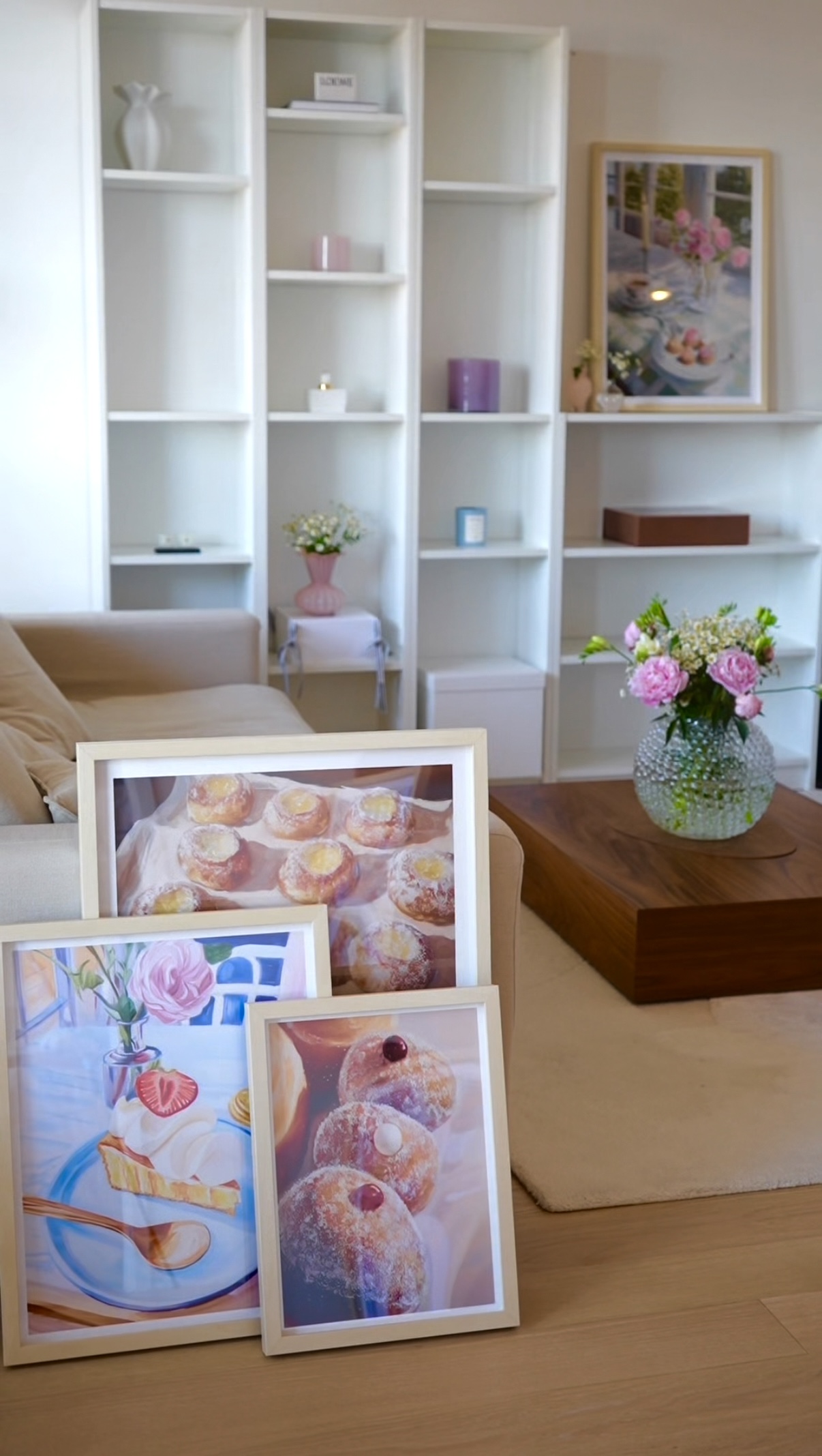 Living room with framed food art and flowers on a table.