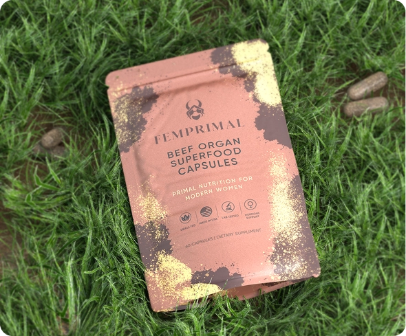 Package of beef organ superfood capsules on grass with scattered capsules.