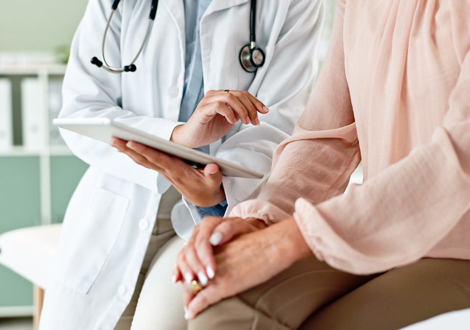 Doctor discussing with patient, using a tablet.
