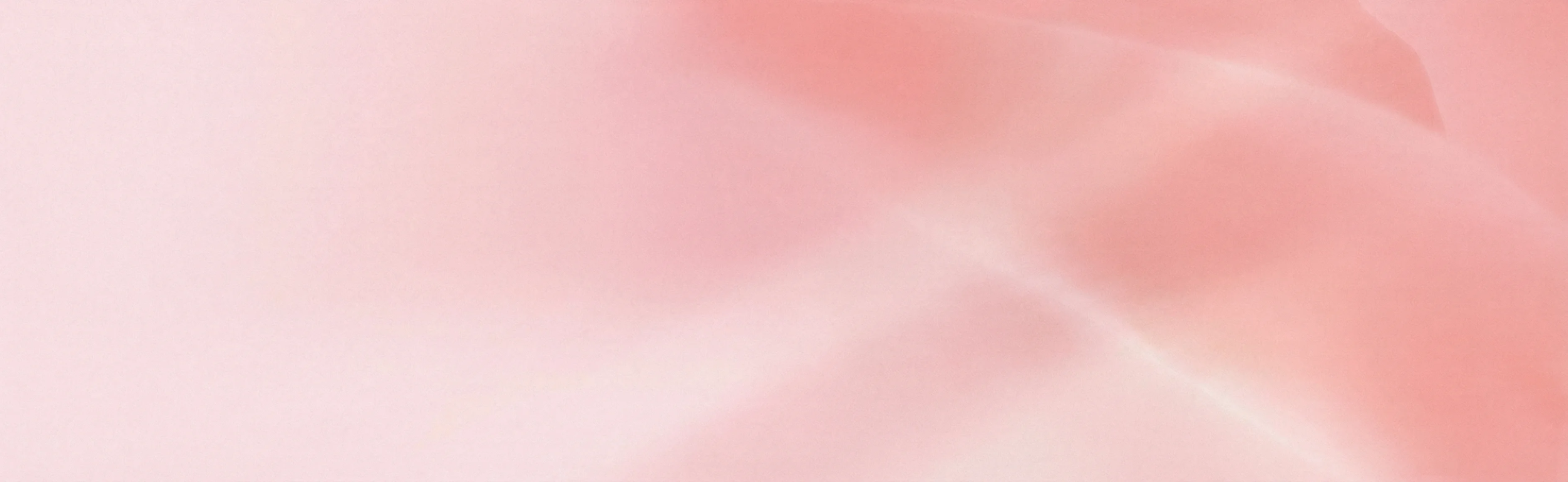 An abstract background with soft, hazy gradients of pink.