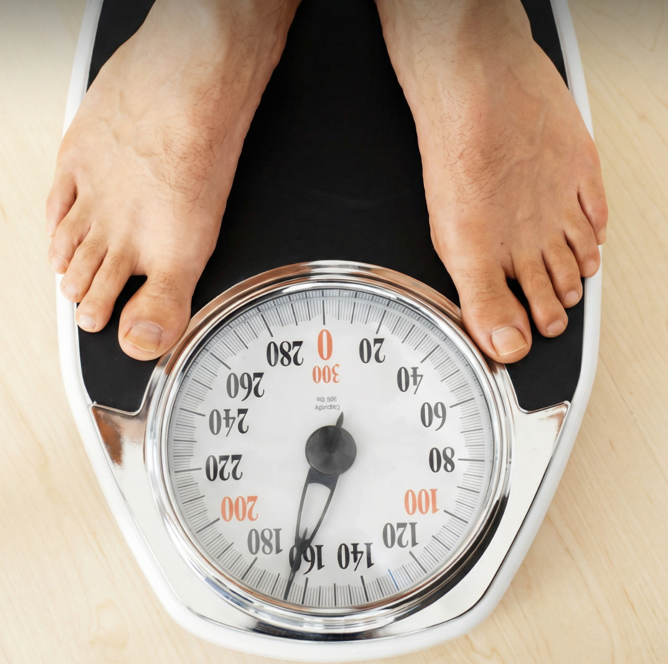Person standing on an analog scale displaying a weight.
