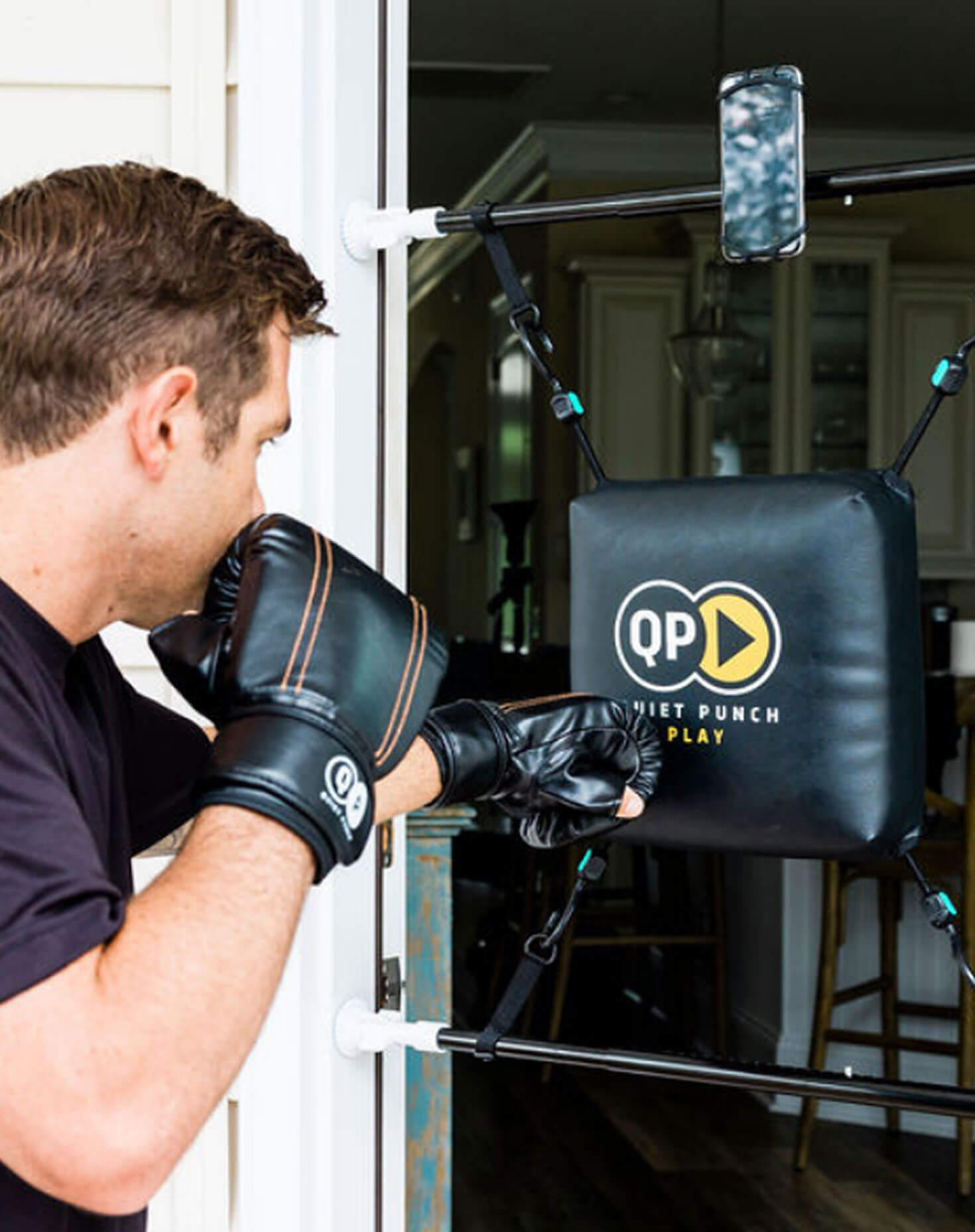 Man wearing boxing gloves using a door-mounted punching pad.