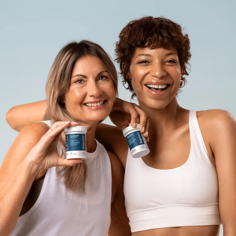 Two smiling women holding supplement containers, wearing white tops.