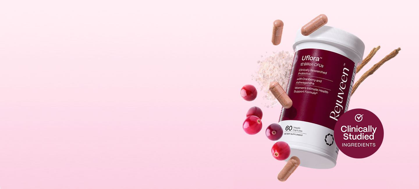 Probiotic supplement bottle with cranberries, capsules, and powder on a pink background.