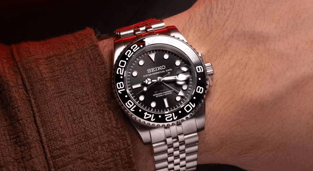 A person wearing a Seiko watch with a black and silver design.