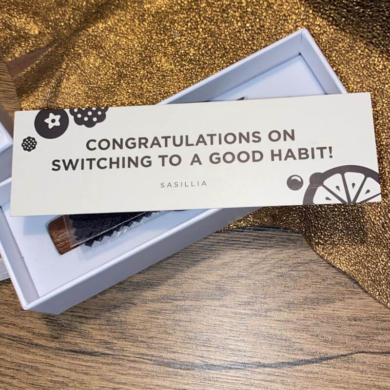 Card with text 'Congratulations on switching to a good habit!' on a wooden box.