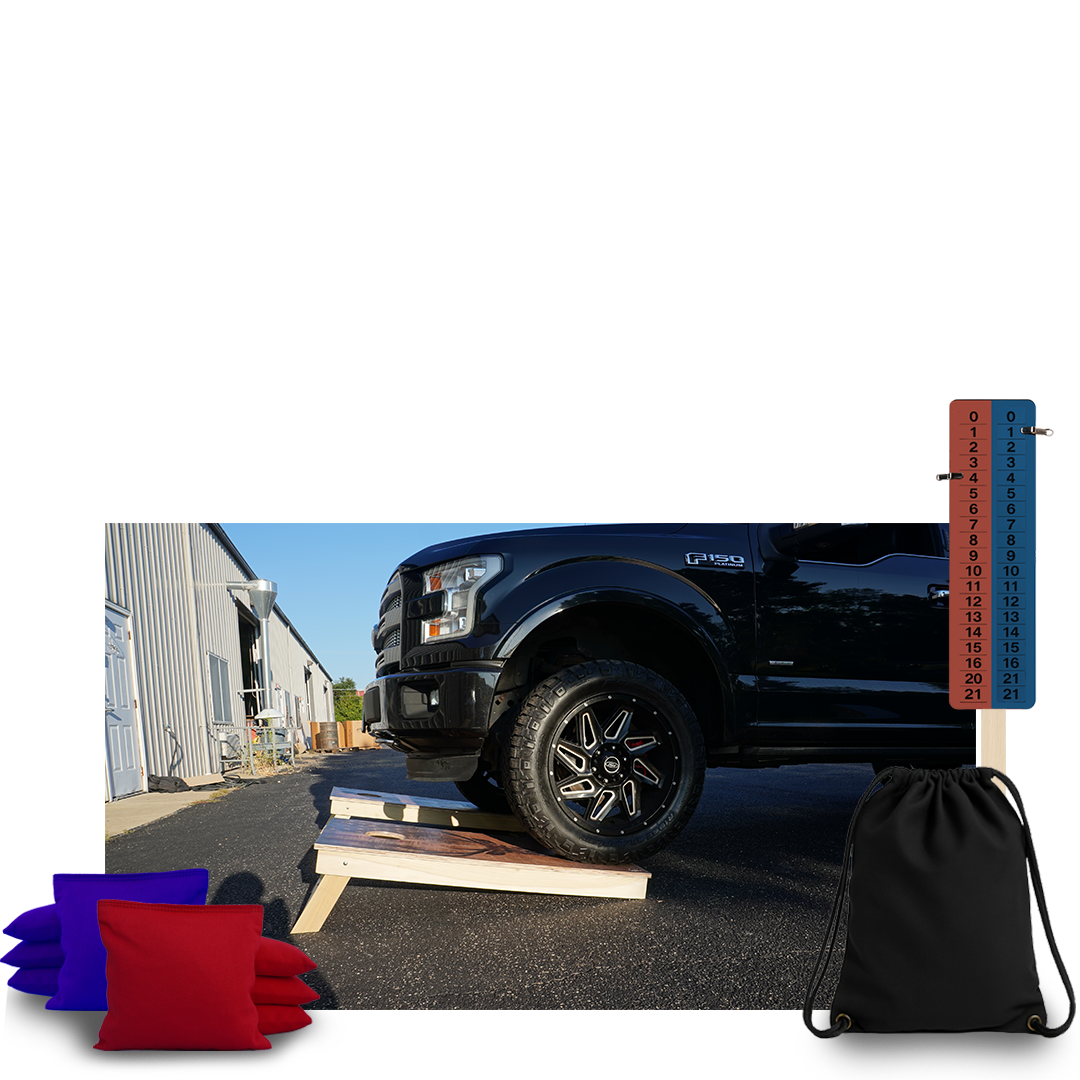 Black truck on a wooden ramp with colored pillows and a drawstring bag nearby.