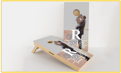 Customized cornhole boards with a wedding photo and 'Rogers' text.