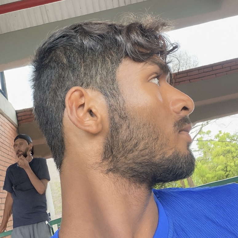 Side profile of a person with short hair, another person in the background.