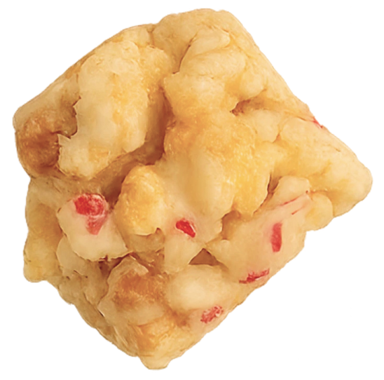A close-up of a puffy snack with red specks.