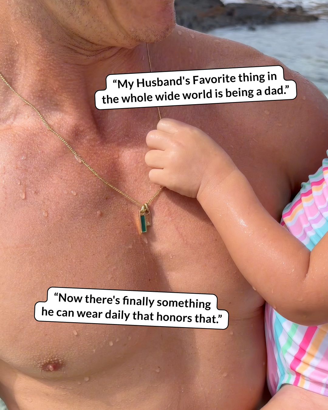 A close-up of a child's hand touching a gold necklace with a green pendant on a man's chest.