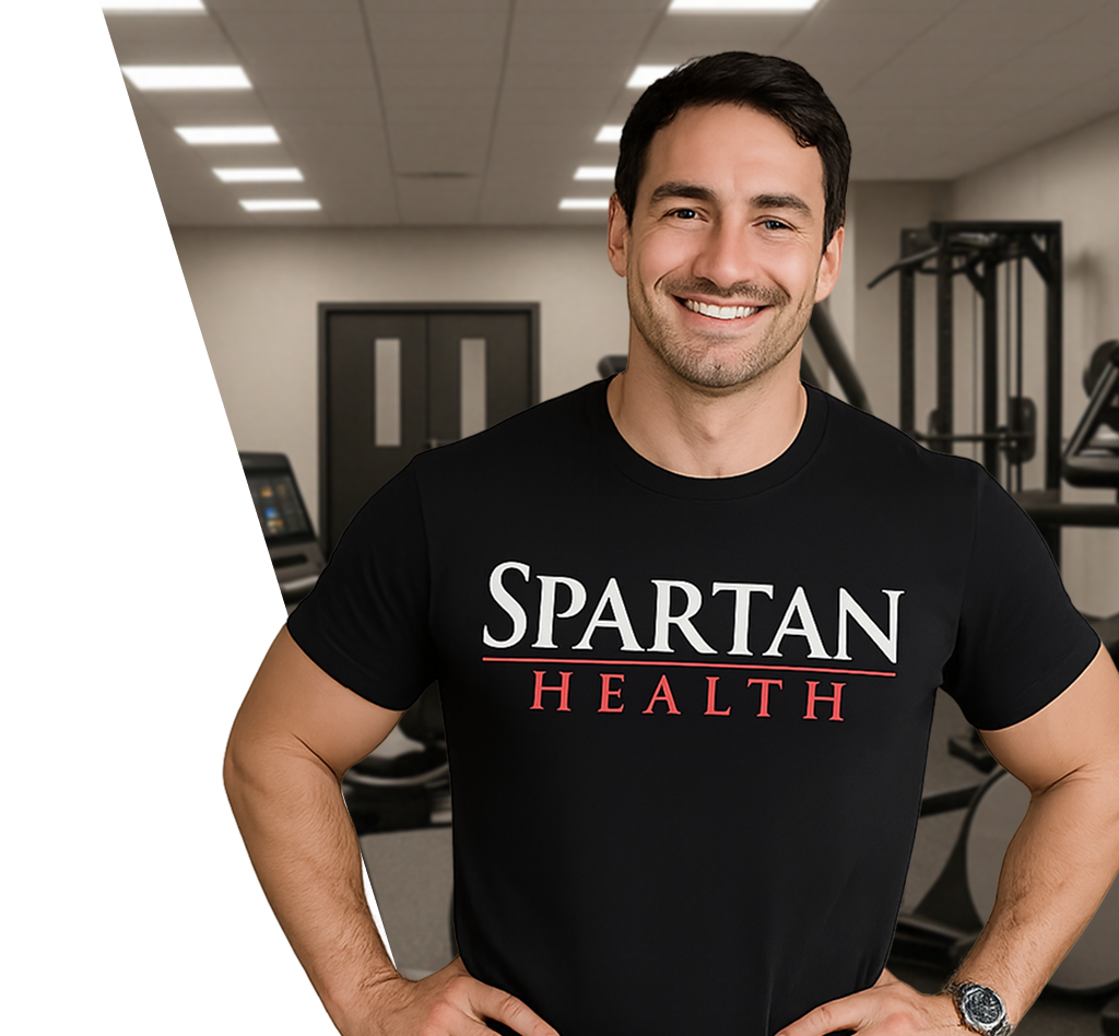 Man in a gym wearing a 'Spartan Health' t-shirt, smiling.