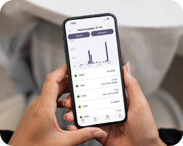 Person holding a smartphone displaying a chart and list on the screen.