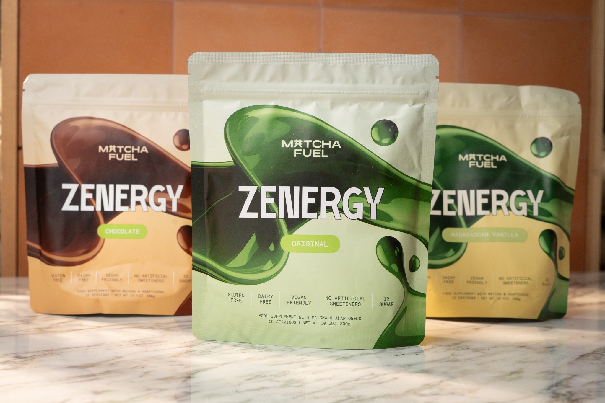 Three Zenergy matcha fuel packages on a marble surface.