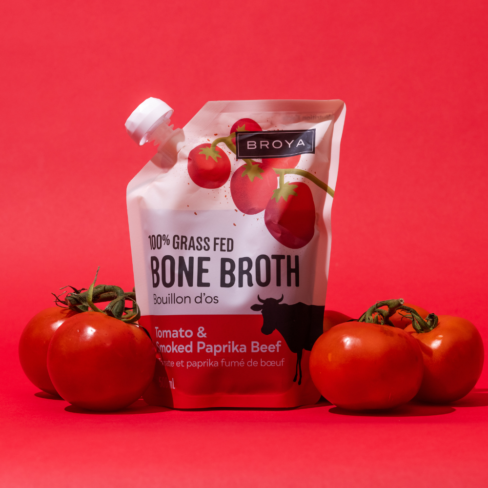 Bone broth pouch with tomatoes on a red background.