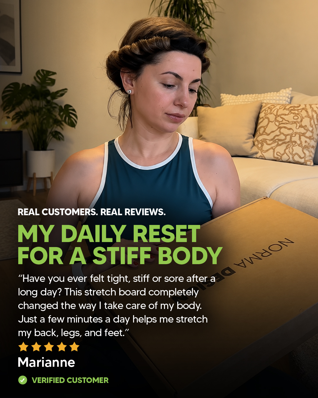 A woman in a teal tank top with her hair in rollers looks down at a cardboard box.