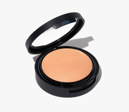 Compact powder case open, showing beige powder inside.