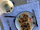 An overhead view of a plate of pancakes with chocolate chips and a fork.