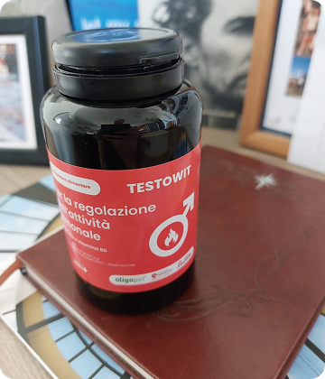 A bottle labeled 'TESTOWIT' on a stack of books.