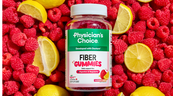 A bottle of Physician's Choice Fiber Gummies sits on a bed of fresh raspberries and lemon slices.
