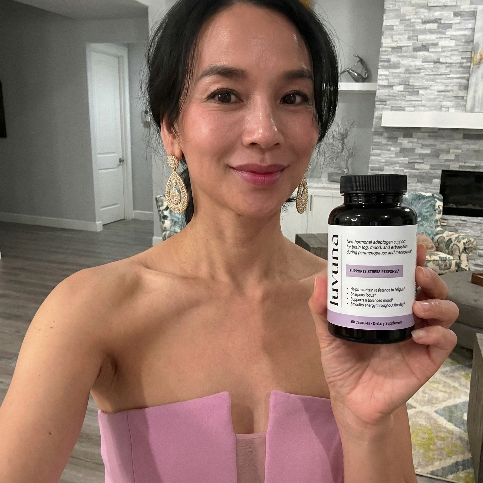 Person holding a bottle of dietary supplement in a living room.