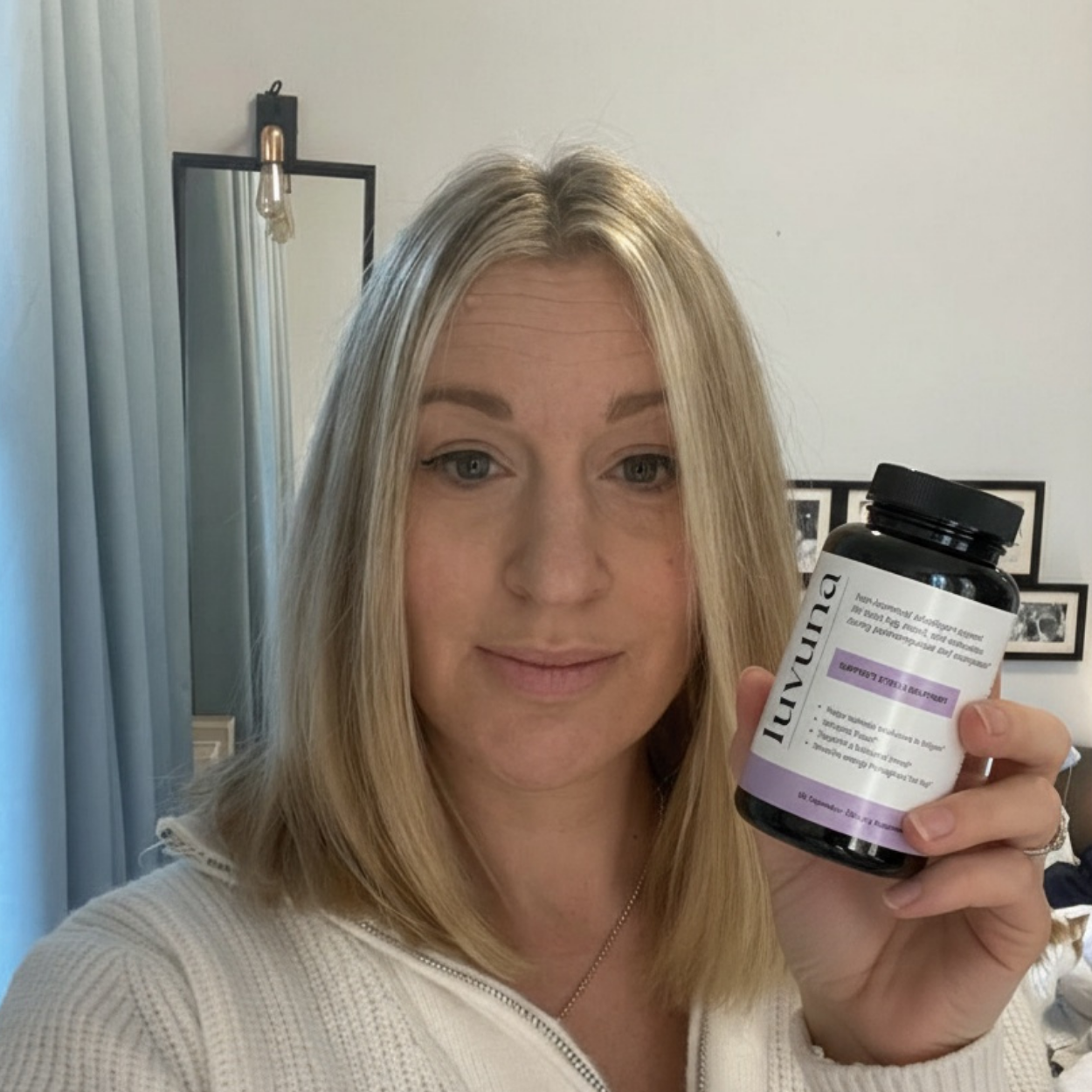 Person holding a bottle labeled 'luvuna' indoors.