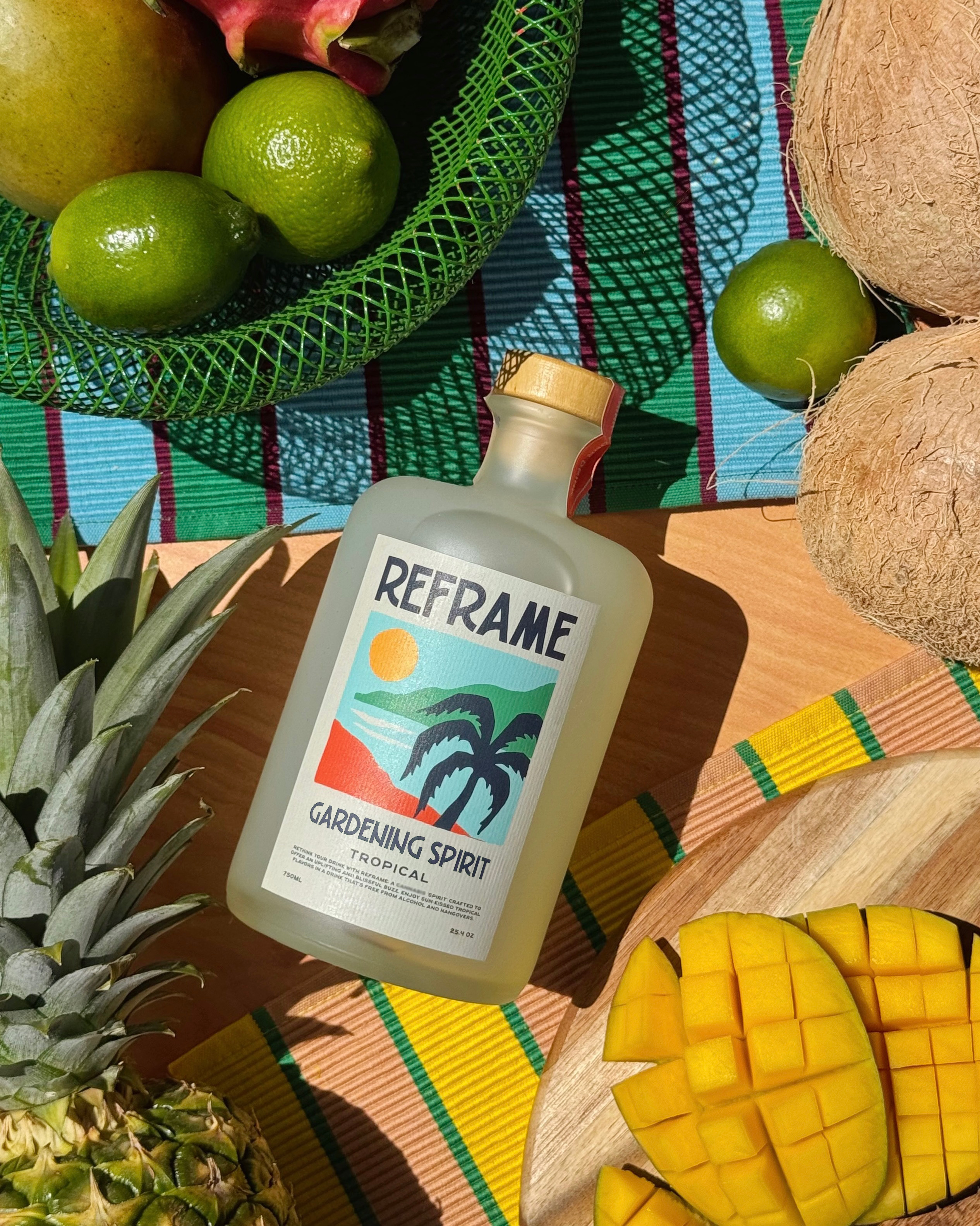 Bottle labeled 'Reframe Gardening Spirit' with tropical fruits.