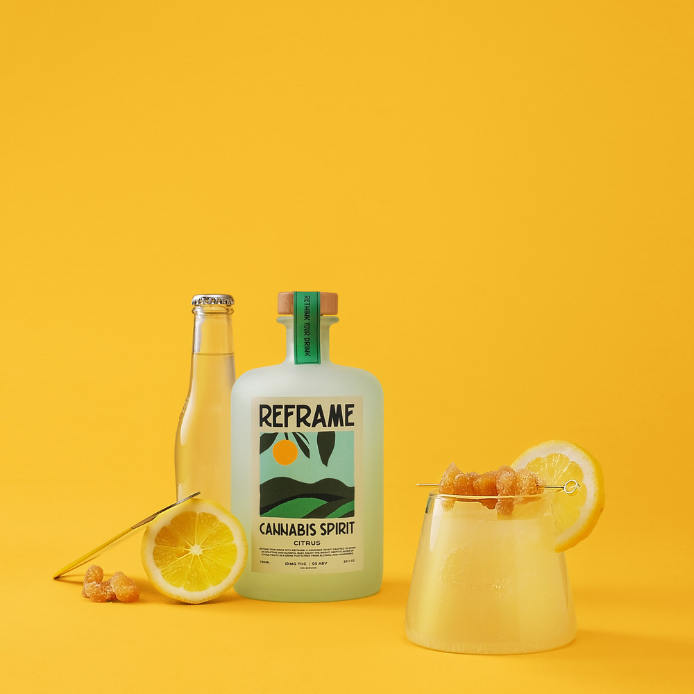 Bottles and a glass with lemon slices on a yellow background.