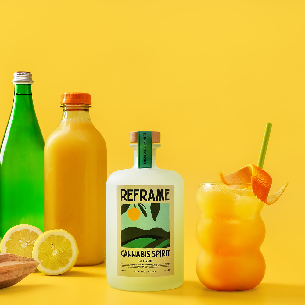 Bottles and a citrus cocktail against a yellow background.