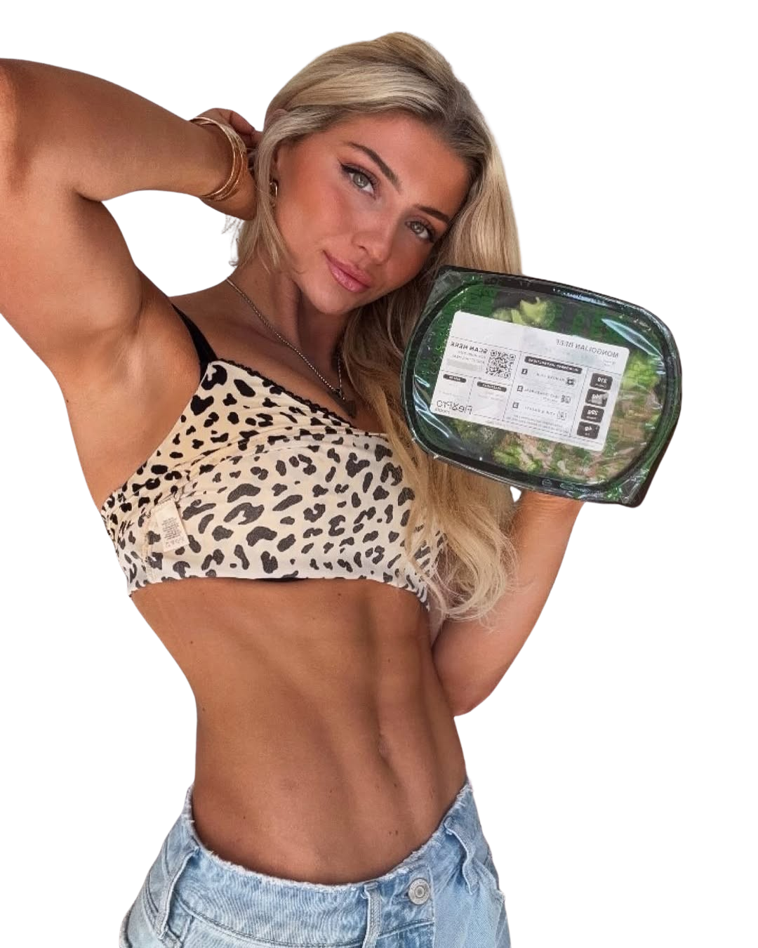 Person holding a packaged salad, wearing a leopard print top and jeans.