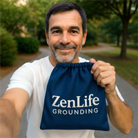 Person holding a blue bag labeled 'ZenLife Grounding' outdoors.