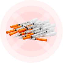 A pile of syringes inside a red circle with a large pink X crossing them out.