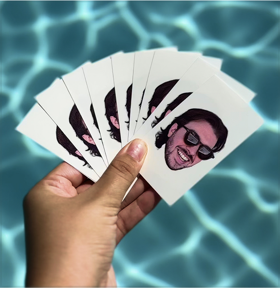Hand holding cards with a smiling face, pool water in the background.