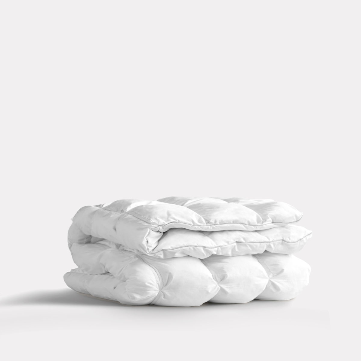 Folded white comforter on a plain background.