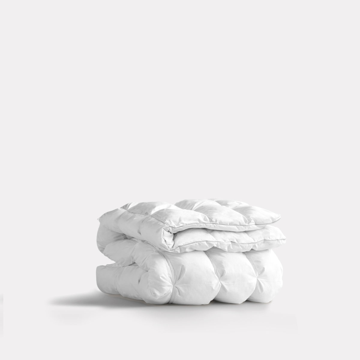 Folded white comforter on a plain background.