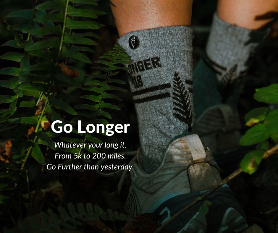 Close-up of legs wearing socks and shoes in a forest.