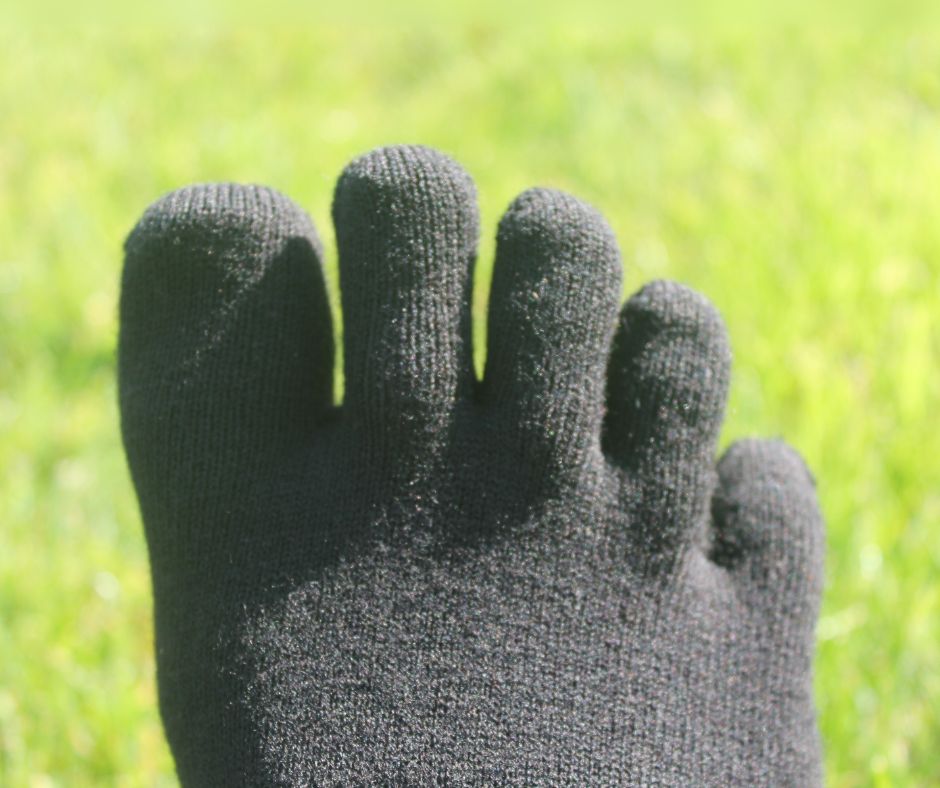 Black toe socks on grass background.