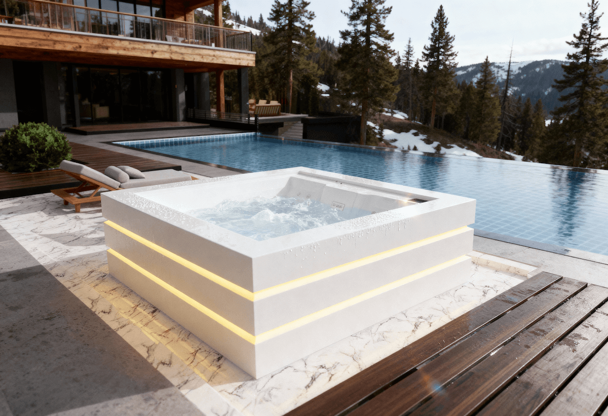 Outdoor hot tub and pool on a snowy mountain background.