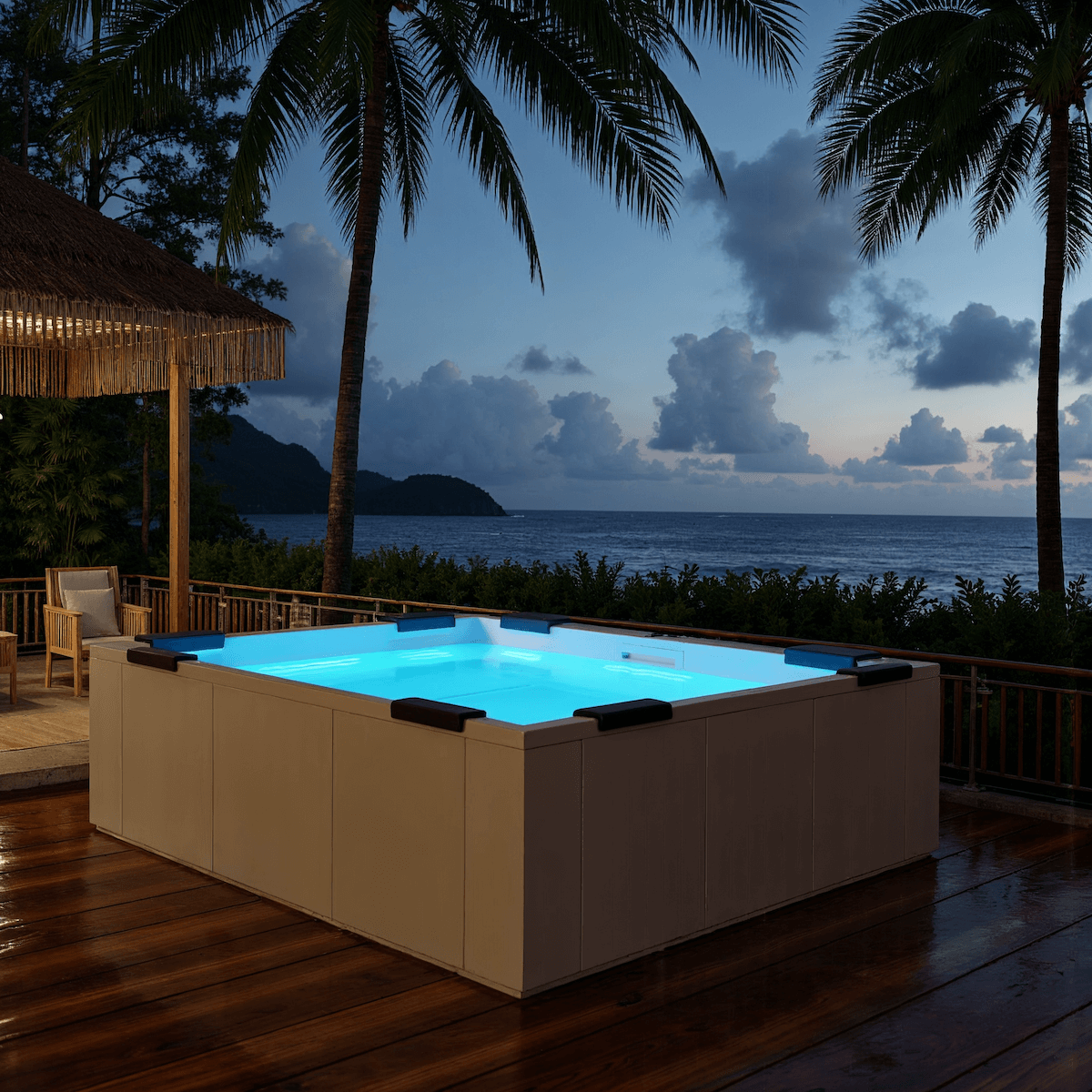 Illuminated pool on a wooden deck by the ocean at dusk, with palm trees and clouds.